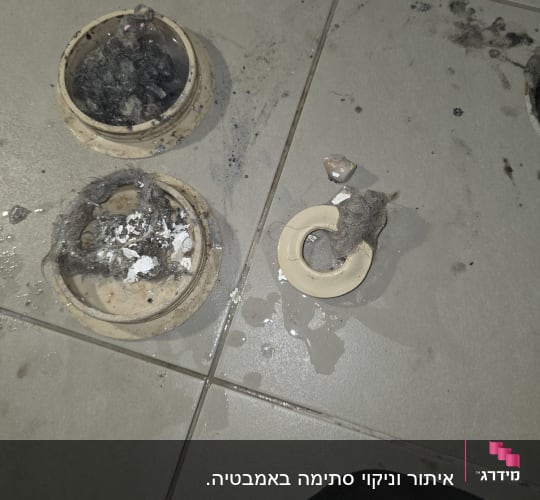 חלקי צנרת מלוכלכים על רצפה רטובה